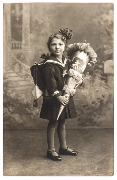 Vintage sepia portrait of a first grader school girl with school — Stock Photo, Image