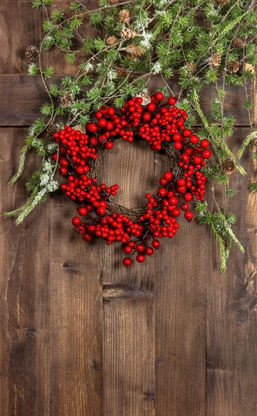 Christmas tree branches and red wreath on wooden — Stock Photo, Image