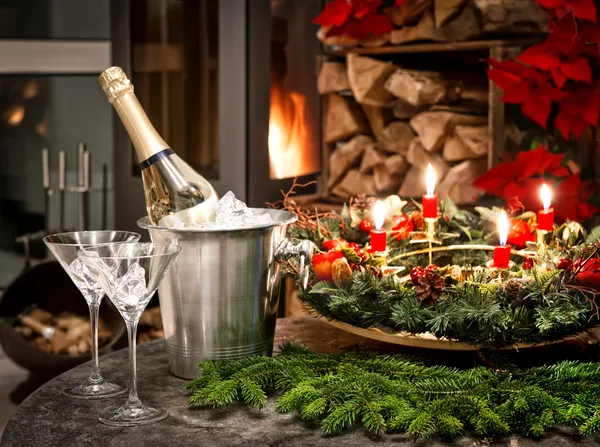 Bottle of champagne, glasses and fireplace — Stock Photo, Image