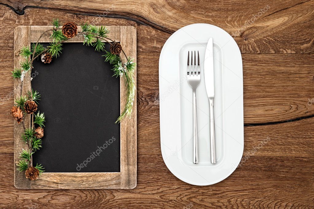 blackboard with christmas tree branches on wooden table