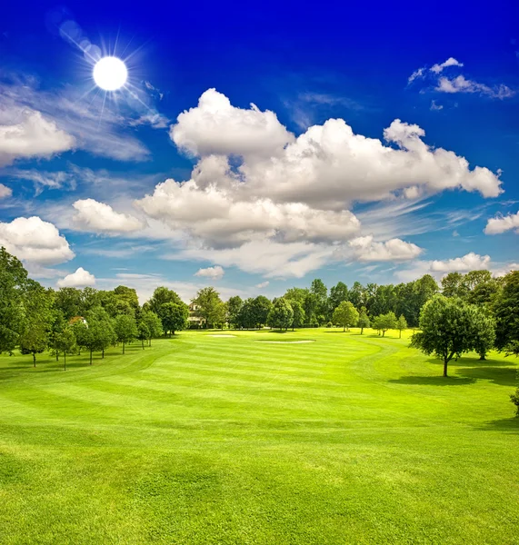 Pole golfowe i niebieski niebo słoneczny. zielone pole krajobraz — Zdjęcie stockowe