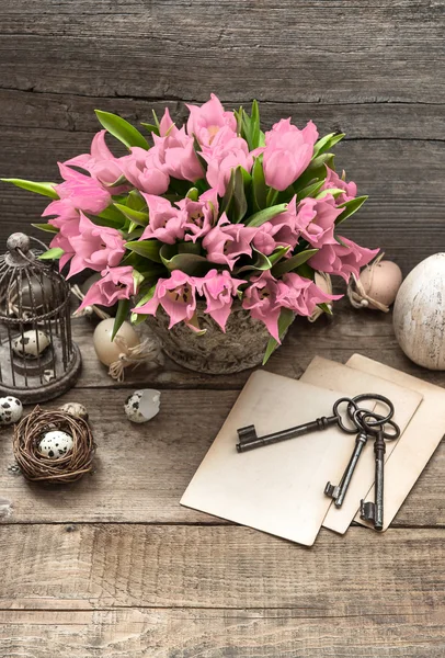 Decoración de Pascua con jaula, huevos y suaves flores de tulipán rosa — Foto de Stock