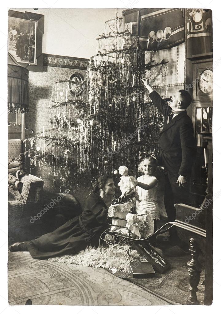 Family portrait of mother, father and child with christmas tree