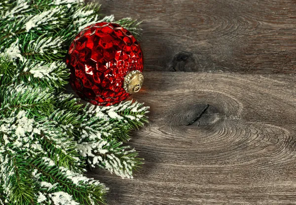 Feestelijke decoratie rode Kerstmis bal met pijnboomtakken — Stockfoto