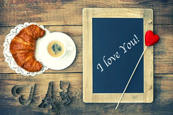 Kaffe och croissant, blackboard och hjärta dekoration — Stockfoto