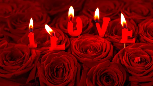 Red roses and burning candles making I LOVE — Stock Photo, Image