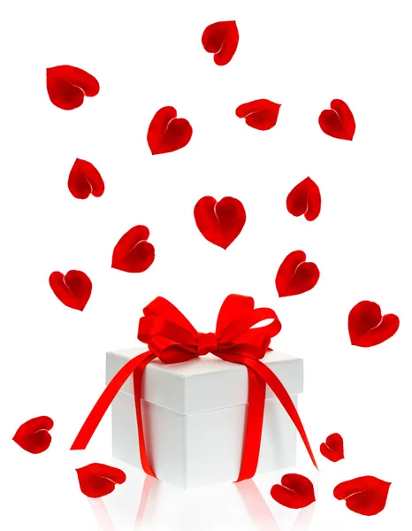 Gift box with red ribbon bow and petals of rose flower — Stock Photo, Image