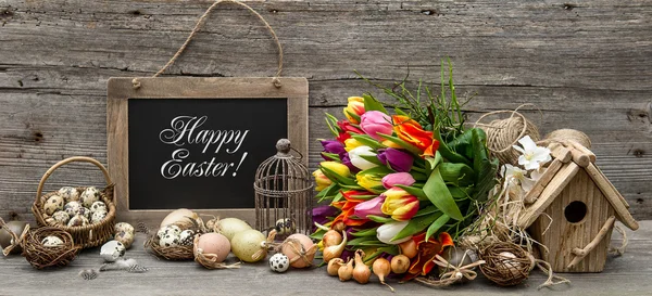 Великодні прикраси з яйцями і квітами тюльпанів — стокове фото
