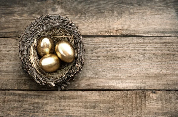 Oeufs de Pâques dorés sur fond en bois — Photo