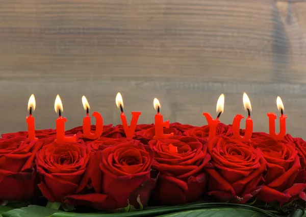 Roses rouges et bougies allumées. Je t'aime. — Photo