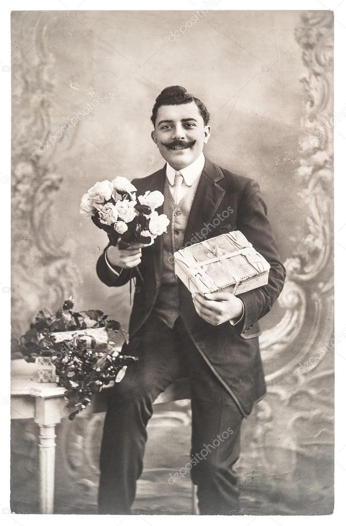 Portrait of young man with rose flowers and gift