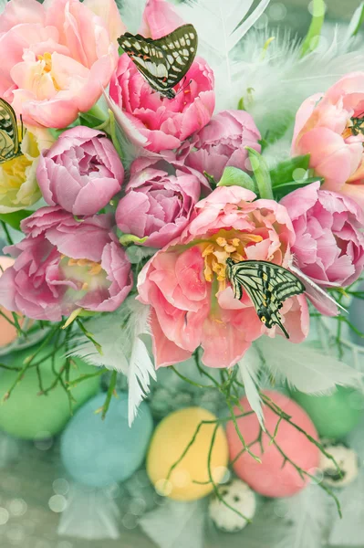 Квіти рожевих тюльпанів, метеликів і кольорових яєць — стокове фото