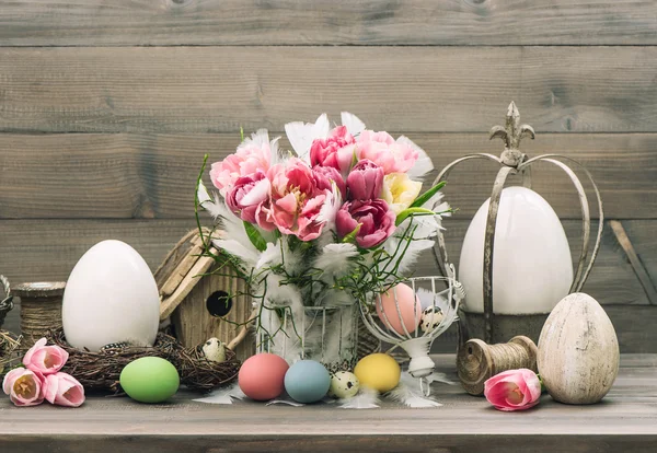 Vida muerta de Pascua. Flores de tulipán y huevos de colores — Foto de Stock