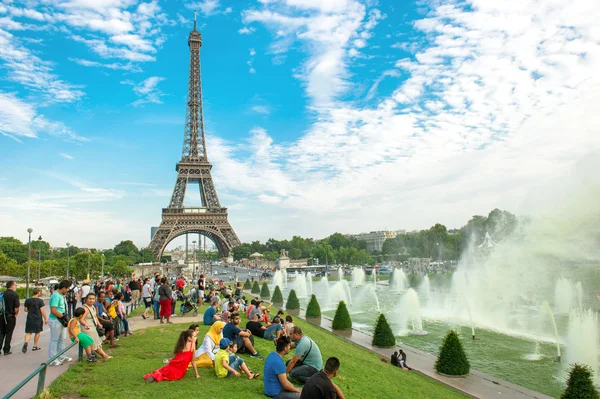 Turystów siedzi w pobliżu słynnego eiffel wieża Paryż — Zdjęcie stockowe