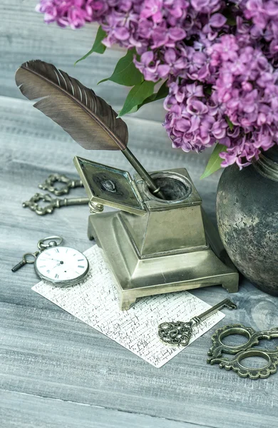 Still life with lilac flowers and antique accessories — Stock Photo, Image