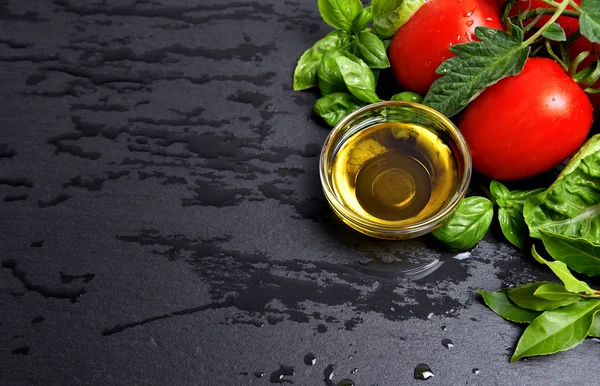 Tomatoes and fresh basil leaves with olive oil — Stock Photo, Image