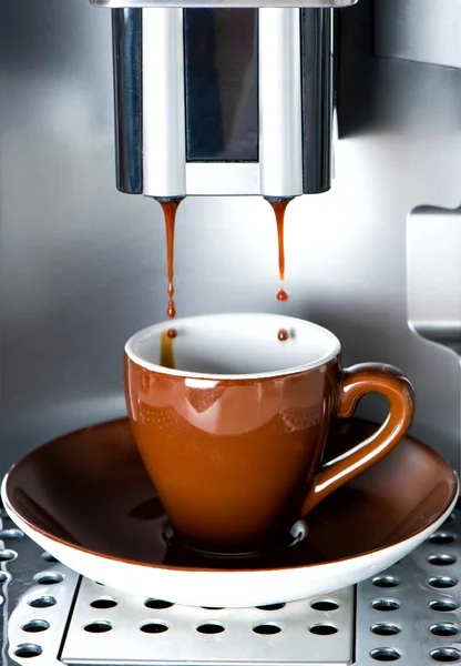 Кофеварка наливая свежий кофе эспрессо в чашку — стоковое фото