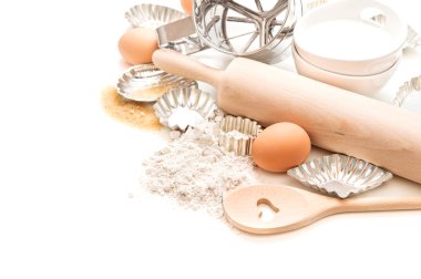 meel, eieren, suiker, rolling pin en cookie cutters op wit