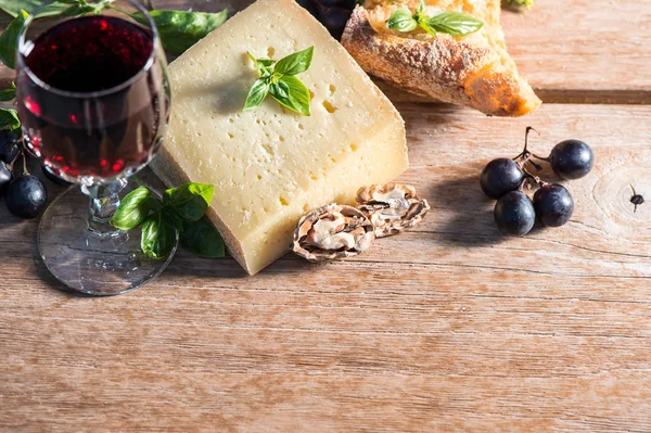 Cheese with red wine, walnuts, basil leaves and grapes — Stock Photo, Image