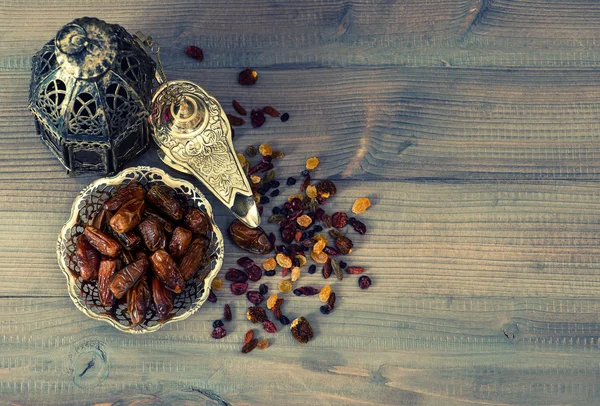 Vintage oriental latern, pasas y dátiles sobre fondo de madera — Foto de Stock