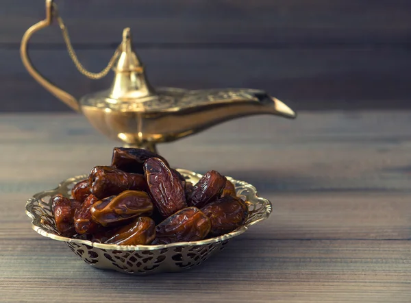 Dates and golden arabian lamp on wooden background — Stock Photo, Image