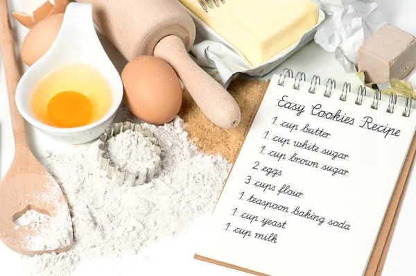 recipe book and cookies ingredients eggs, flour, sugar, butter,