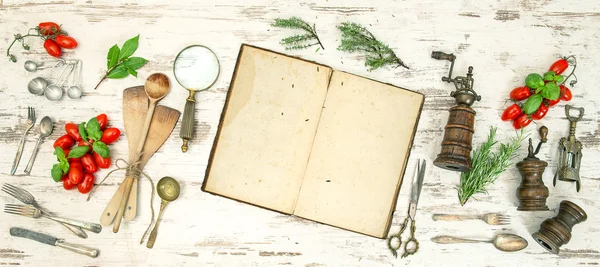 Vintage kitchen utensils with old cookbook, vegetables and herbs — Stock Photo, Image