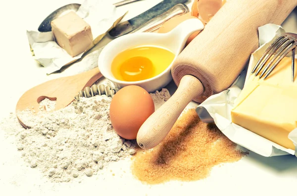 Bakning ingredienser ägg, mjöl, socker, smör, jäst — Stockfoto