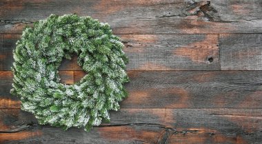 Kırsal ahşap arka planda karlı Noel çelengi