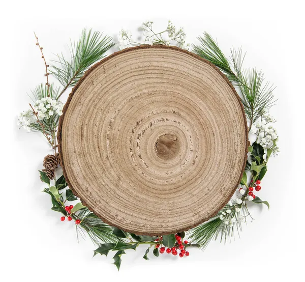 イレックスの葉と松の木の枝からのクリスマスリースと木製の丸印 — ストック写真