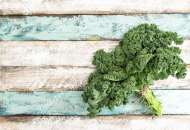 Kale green vegetable cabbage leaves on wooden background. Organic food