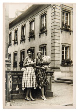 Old photo of fashion women in the city outdoors. Vintage picture with original film grain and blur from ca. 1960