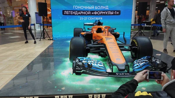 Minsk, Belarus - 27 Eylül 2020: gösteri gösterisi McLaren yarış arabası bolide sergilenmektedir. Süper yakın çekim yüksek teknolojili yarış arabası. Genç adam spor arabasıyla fotoğraf çekiyor. Kalabalık..