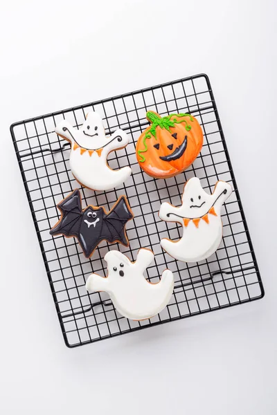 Halloween pierniki ciasteczka na stojaku do pieczenia na białym tle. Jasne domowe ciasteczka na Halloween party — Zdjęcie stockowe