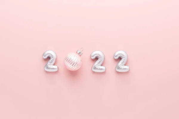 Composição do ano novo com números de prata 2022 e bola de Natal no fundo rosa. Celebração do ano novo — Fotografia de Stock