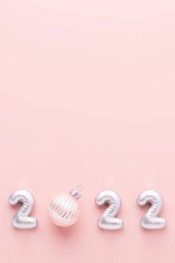 2022 gümüş sayılı yeni yıl kompozisyonu ve pembe arka planda noel balosu. Metnin için boşluk kopyala