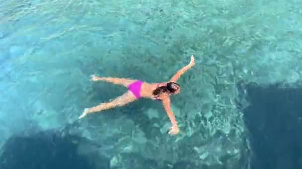 Menina nadando em água do mar azul-turquesa clara. Vista de cima — Vídeo de Stock