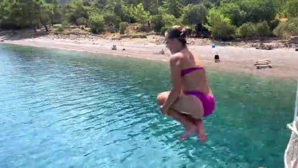 Young girl jumping into the blue sea from boat on vacation — Stock Video