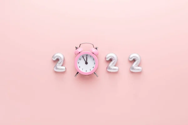 Серебряные номера 2022 и будильник на розовом фоне. Празднование Нового года. С Новым годом — стоковое фото