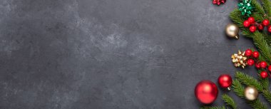 Köknar ağacı ve koyu taştan arka planda kırmızı süslemeli yatay afiş. Üst Görünüm Kopyalama alanı