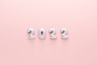 Pembe arka planda gümüş sayılar 2022. Yeni yıl kutlaması. Mutlu yeni yıl kavramları