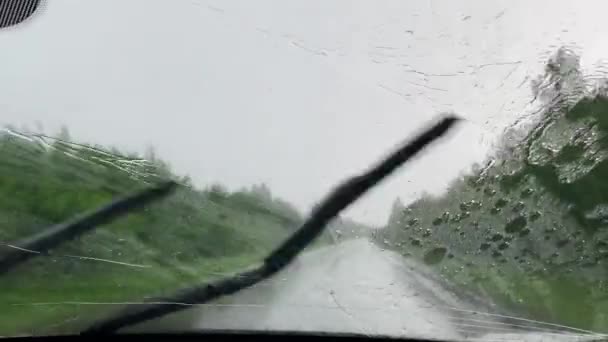 Вождение под проливным дождем. Дождь попал в лобовое стекло. Внутренний вид автомобиля — стоковое видео
