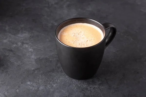 Becher mit frischem Kaffee auf dunklem Steingrund. Kopieren Sie Platz für Ihren Text — Stockfoto