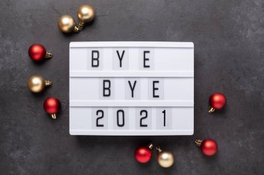 Güle güle mesajı olan ışık kutusu. 2021, koyu arkaplan süslemeli. Üst Manzara. Yeni yıl kutlaması. Mutlu yıllar 2022 kavramları