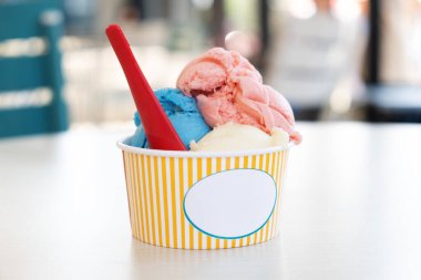 Sıcak bir günde, sokak kafesinde farklı tatlara sahip parlak dondurmalı kağıt bardak atıştırmalıkları tazeliyor.