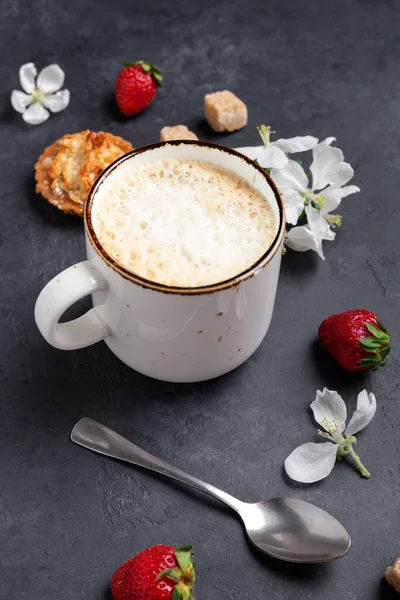 Tasse Kaffee mit Kuchen und Frühlingsblumen auf dunklem Steingrund — Stockfoto