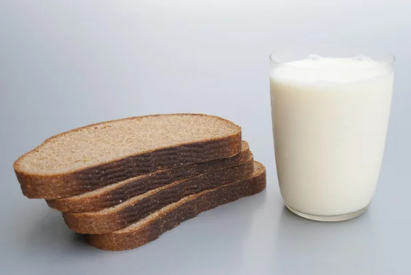 Sliced ​​brown bread and milk — Stock Photo, Image