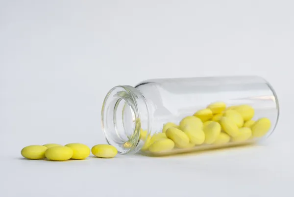 Пляшка з жовтими таблетками — стокове фото