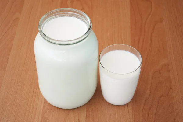 Pot en verre et un verre de lait — Photo