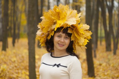 Sonbahar parkında akçaağaç yapraklı bir kız.